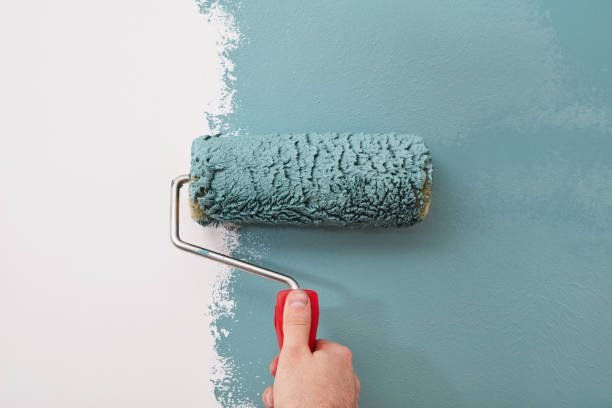 male hand painting wall with paint roller male hand painting wall with paint roller