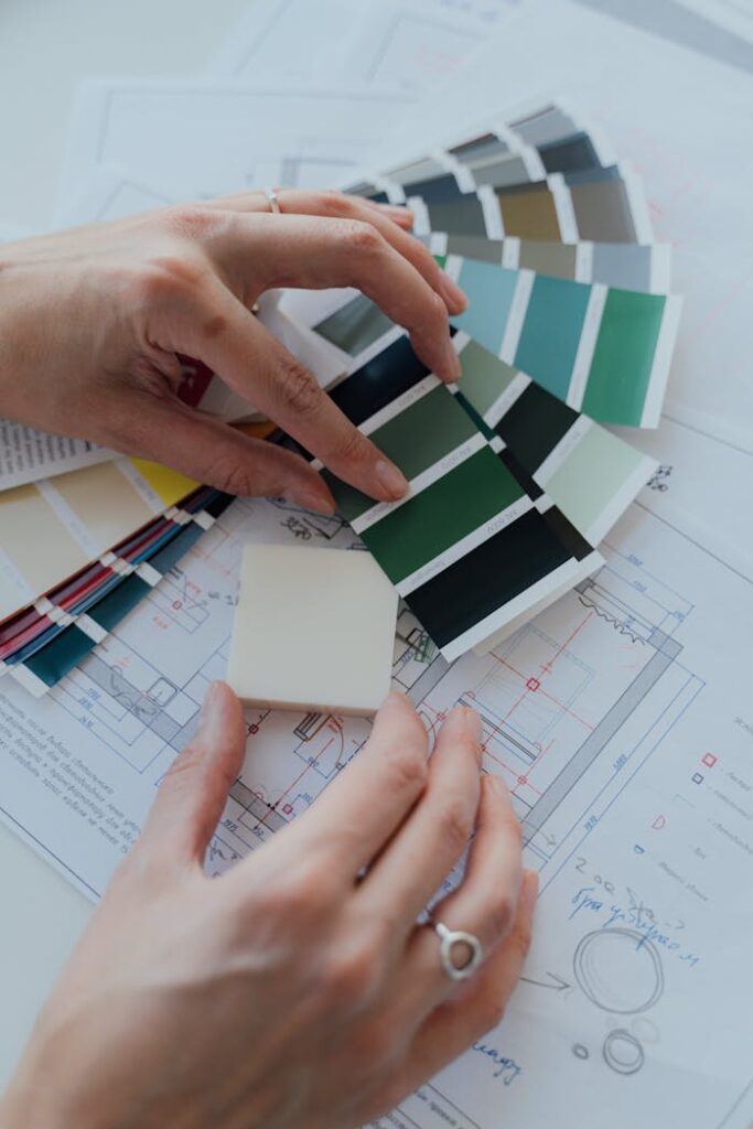 pexels photo 5292198 Hands selecting color samples over architectural plans for interior design.